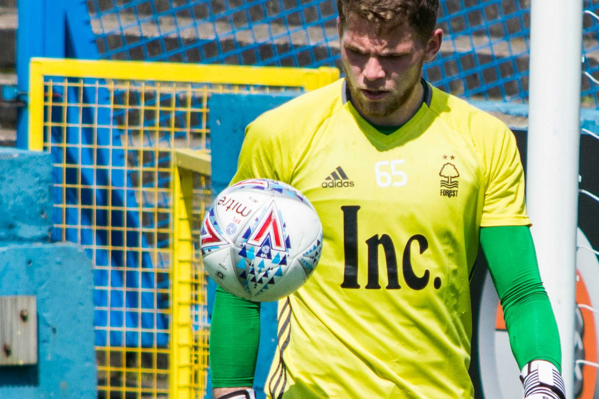 Un maillot de foot pas cher porté par un joueur devant une balle de football